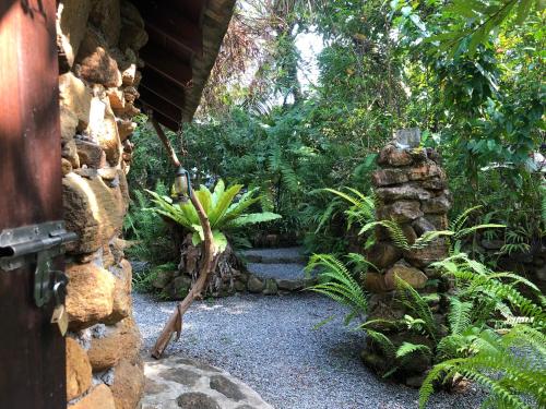 a garden with a stone wall and some plants at Villa rock by earth house in Matugama