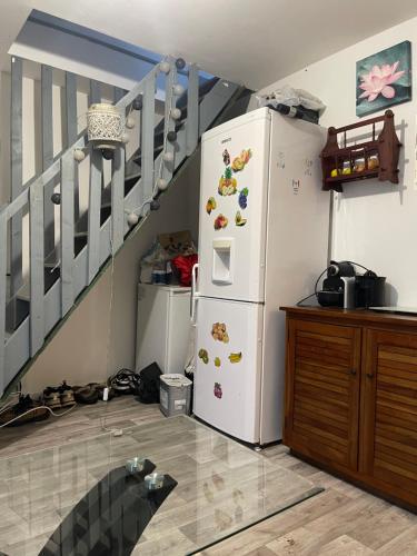 - un réfrigérateur blanc dans une cuisine avec un escalier dans l'établissement Chambre charmante, à Roubaix