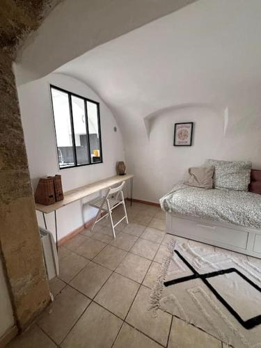 une chambre avec un lit, un bureau et une fenêtre dans l'établissement Appartement maison mas provençal, à Pélissanne