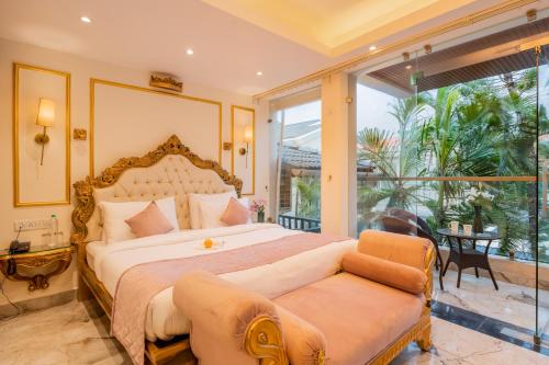 a bedroom with a large bed and a large window at Emperor Ozran by Alaya Stays in Vagator