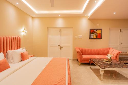 a bedroom with a bed and a couch and a table at Emperor Ozran by Alaya Stays in Vagator