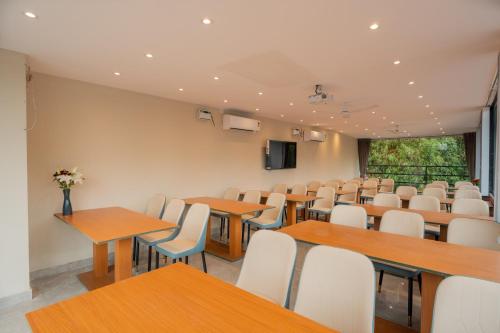 a conference room with tables and chairs and a screen at Emperor Ozran by Alaya Stays in Vagator