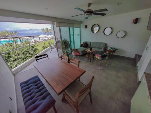 a living room with a table and a couch at Beachfront Bliss at Aria Ocean Flamingos in Nuevo Vallarta