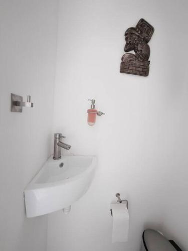 a white bathroom with a sink and a toilet at Beachfront Bliss at Aria Ocean Flamingos in Nuevo Vallarta