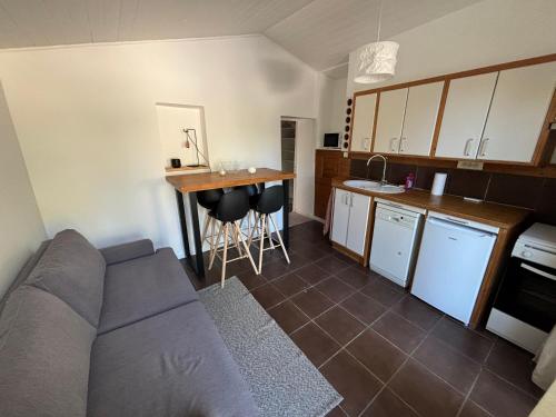 un salon avec un canapé et une cuisine dans l'établissement Maisonnette face au Garlaban, à Roquevaire