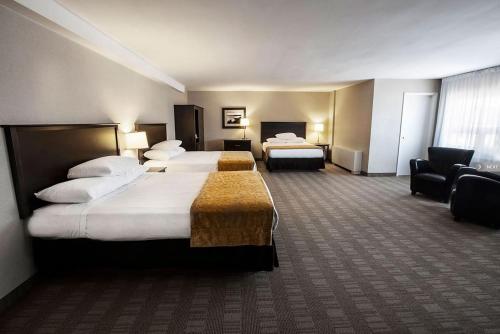 a hotel room with two beds and a couch at Skyline Hotel & Waterpark in Niagara Falls