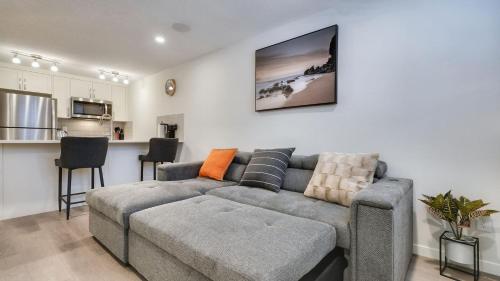 a living room with a couch and a kitchen at Cozy place to stay in south Calgary in Calgary