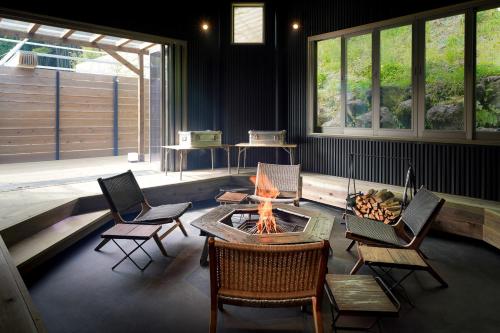 a living room with a fire pit and chairs at The BASE GLAMPING YUGAWARA in Yugawara