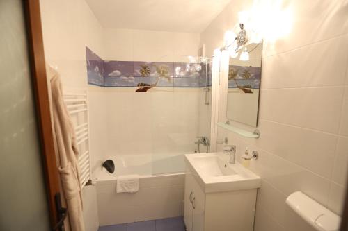 a white bathroom with a sink and a mirror at Apartament Maria in Galaţi