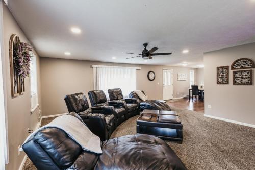 a living room with leather furniture and a ceiling fan at Indoor Hot-Tub! Spacious & Updated MQT Township Home! in Marquette