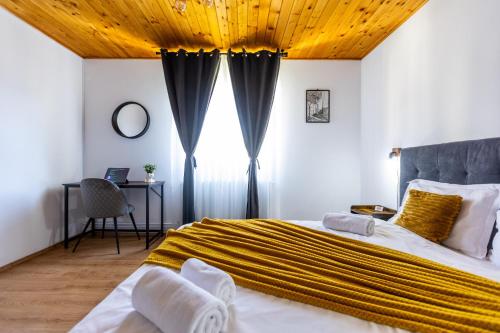 a bedroom with a large bed with a wooden ceiling at Villa Falco Bianco in Buşteni