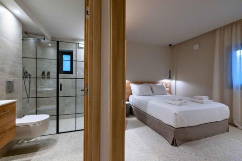 a bedroom with a bed and a bathroom with a shower at Asklipiou Cube - Kalamata Mediterranean Suites in Kalamata