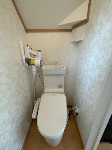 a bathroom with a white toilet in a room at キズキノホテル in Morioka