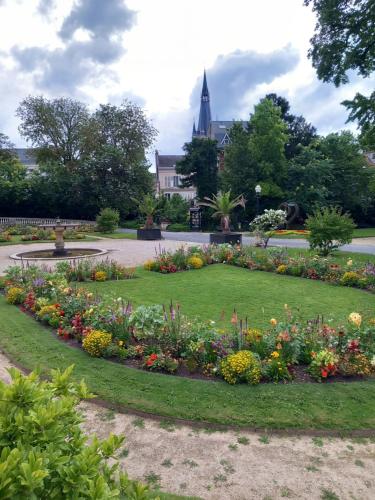 a circular garden with flowers in a park at Les Loges Du Théatre 160m2 PRIVÉ 14 personnes MAX tout équipé a 200m de l'AVENUE DE CHAMPAGNE et toutes commodités DEGUSTATION CHAMPAGNE OFFERTE jacuzzi sauna jeux velos EMPLACEMENT EXCEPTIONNEL et CHIC in Épernay
