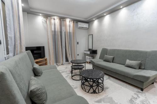 a living room with two couches and a tv at BSP RENT ROOMs in Paralia Sikias