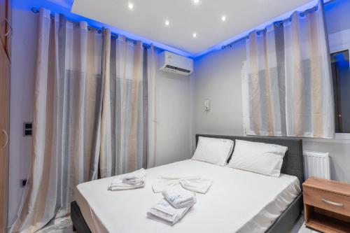 a bedroom with a bed with white sheets and curtains at BSP RENT ROOMs in Paralia Sikias