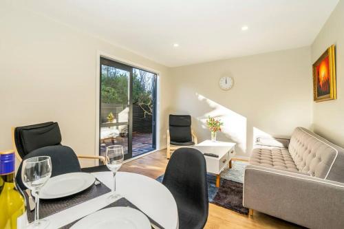a living room with a couch and a table and chairs at Family friendly - 10min drive to Chch city centre in Christchurch
