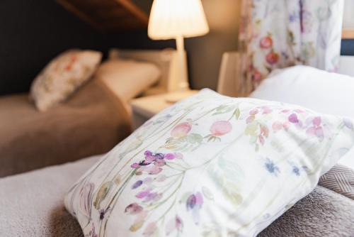 a pillow with flowers on it sitting on a bed at 4月リニューアルOpen! 全室エアコン完備! Deerview Lodge 山中湖 in Yamanakako