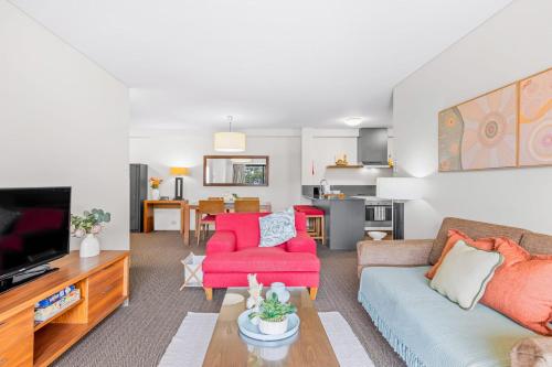 a living room with a couch and a tv at Apartment with City Views in East Perth in Perth