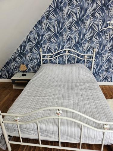 a bed in a bedroom with a blue and white wallpaper at Authentique maison Morlaisienne in Morlaix