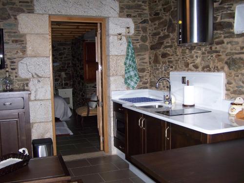 a kitchen with a sink and a counter top at Casa Rural Dona María in Ordes