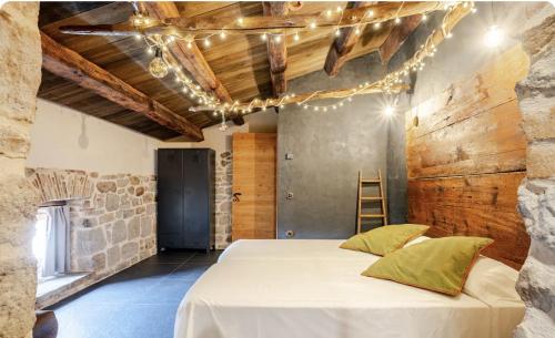 a bedroom with a bed and a stone wall at La Torreta d'Olius in Olíus