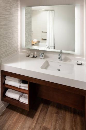 a bathroom with a white sink and a mirror at Palm Beach Gardens Marriott in Palm Beach Gardens