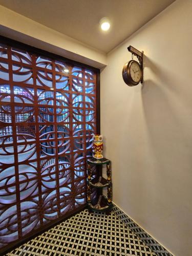 a room with a window with a clock on the wall at SANTINIKETAN RETREAT, Bolpur in Shānti Niketan