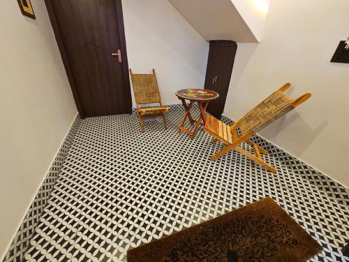 a room with two chairs and a table and a door at SANTINIKETAN RETREAT, Bolpur in Shānti Niketan