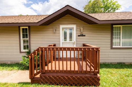 a wooden deck in front of a house at Indoor Hot-Tub! Spacious & Updated MQT Township Home! in Marquette