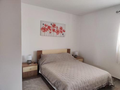 a bedroom with a bed and two tables and a picture at Villa Niko in Porat