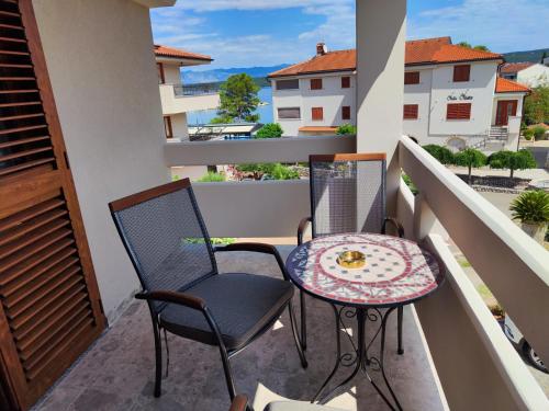 a balcony with a table and chairs on a balcony at Villa Niko in Porat