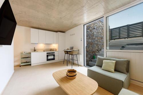 una sala de estar con un sofá y una mesa en Sea Pearls Villas, en Ampelas