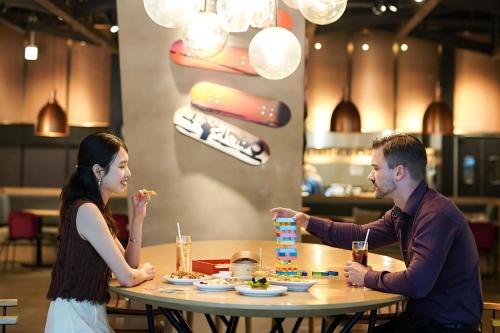 a man and woman sitting at a table eating food at Aloft Osaka Dojima in Osaka