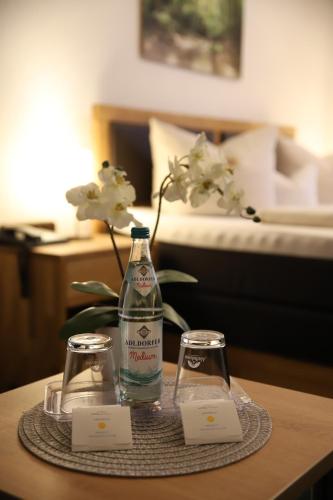 a bottle of water and two glasses on a table at Hotel zur Isar in Plattling