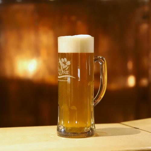 a glass of beer sitting on a table at Hotel zur Isar in Plattling