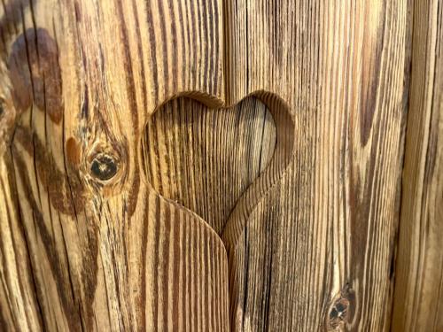 a wooden wall with a heart carved into it at Rooms Dreisiebner at the Heart in Zgornja Kungota