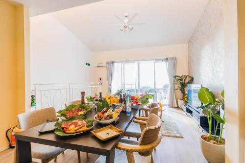 a dining room with a table with food on it at Alpha Terrace Onna Hills in Onna