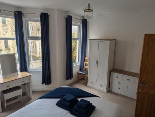 a bedroom with a bed and a desk and windows at Prospect House in Bangor