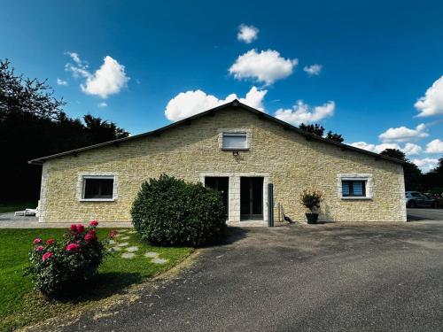 a brick house with flowers in front of it at La maison Girafe in Faverolles