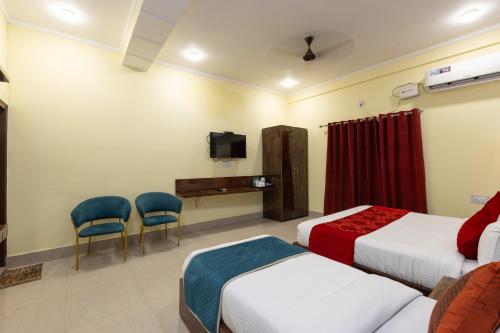 a hotel room with two beds and a tv at Indira Nikunj Rubystone Exotic in Rishīkesh