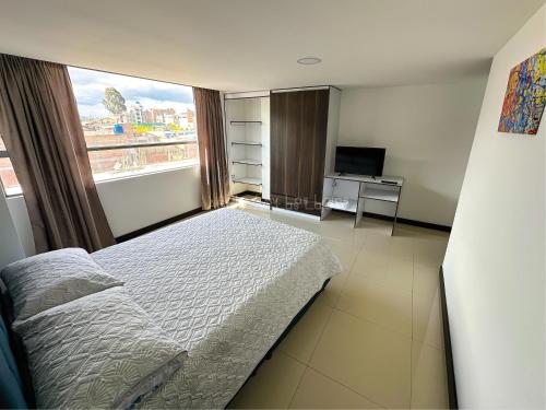 a bedroom with a bed and a large window at Apto 401 / Av. Las Lajas in Ipiales