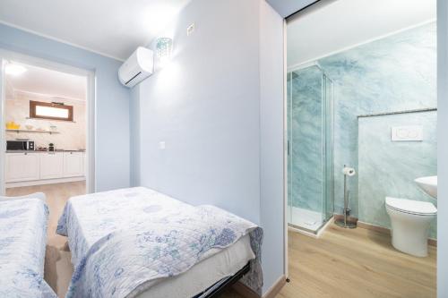 sypialnia z łóżkiem i łazienką z prysznicem w obiekcie Villetta Residence Porto Corallo w mieście Villaputzu