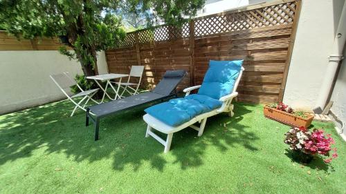 une cour arrière avec un lit, deux chaises et une table dans l'établissement Chez LOLO CHAMBRE DOUBLE 14,60 M2, à Pessac