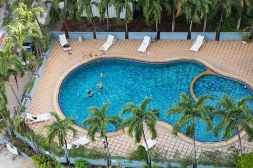 an overhead view of a large swimming pool with palm trees at Sawasdee Siam Hotel in Pattaya Central