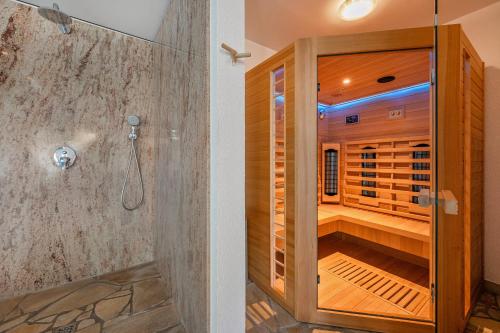 a shower in a bathroom with a wooden cabinet at Coastal Breeze Usedom in Heringsdorf