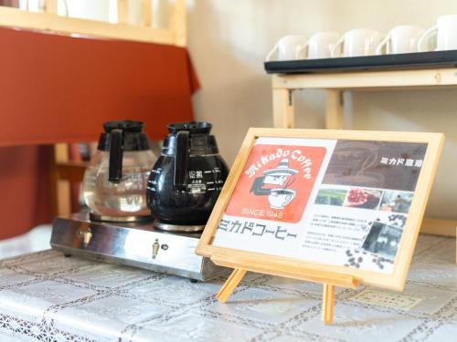 a sign sitting on a table with two coffee pots at APA Hotel Karuizawa Ekimae Karuizawaso in Karuizawa