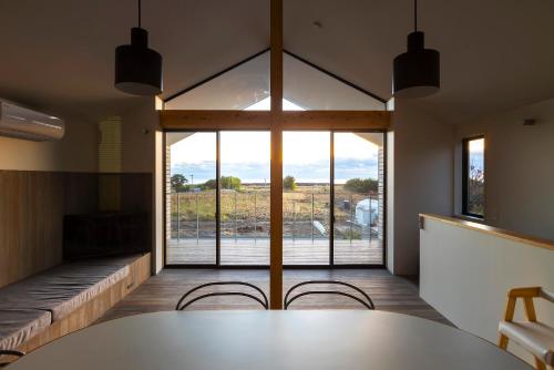 a room with a table and chairs and a large window at 宮崎 海辺の貸別荘 noiro 野島 in Miyazaki