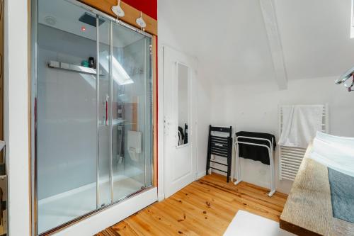 a glass shower in a room with a table at La petite Hautière in Plouër-sur-Rance