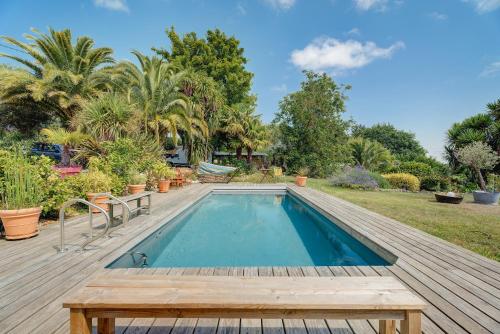 - une piscine sur une terrasse en bois avec une table en bois dans l'établissement La petite Hautière, à Plouër-sur-Rance